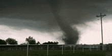 a tornado is coming through a fenced in area with orbo written on the bottom right