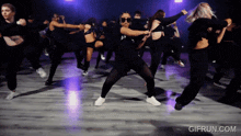 a group of women are dancing in a room with purple lights and the website gifrun.com is displayed