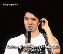a man is holding a microphone in his mouth and saying `` sehun in chinese , thank you everyone ! ''
