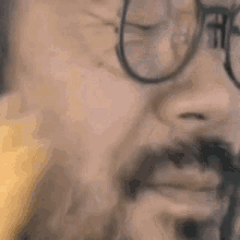 a man with a beard and glasses is making a funny face .