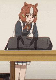 a girl is sitting at a table with a duffel bag .