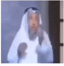 a man in a white robe is standing in front of a glass door .