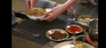 a person is putting a bowl of food on a table