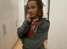a young man with dreadlocks is standing in a hallway