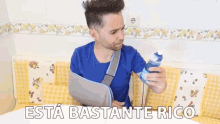 a man with a broken arm is holding a spray bottle and the words esta bastante rico are above him