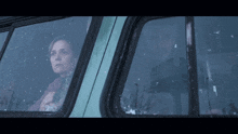 a man and a woman are looking out the window of a vehicle