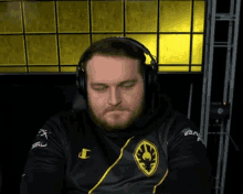 a man wearing headphones and a black shirt with a champion logo