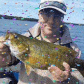 a man is holding a large fish in his hands