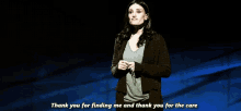 a woman stands on a stage and says " thank you for finding me and thank you for the care "