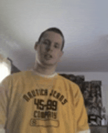 a man wearing a yellow shirt with the number 45 on it is standing in a room .