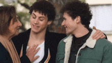 a woman is touching a man 's chest while two other men are standing next to each other