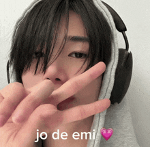 a young man wearing headphones shows a peace sign with the words jo de emi written below him