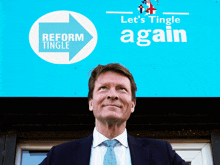 a man in a suit and tie stands in front of a blue sign that says let 's tingle again