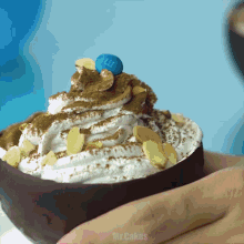 a person is holding a dessert with whipped cream and m & m 's