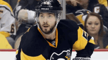 a hockey player wearing a bauer helmet and jersey