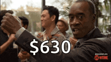 a man in a suit says $ 630 in a crowd of people