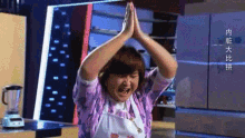 a woman wearing an apron with chinese writing on it is praying
