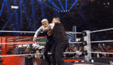 two men are wrestling in a wrestling ring with a sign that says raw in the background