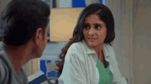 a woman in a white shirt is looking at a man