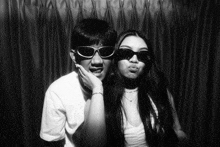 a man and a woman wearing sunglasses are posing for a picture