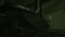 a statue of a man is laying down in a dark room with a green light behind it