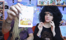 a woman in a wig holds up a card that says idol