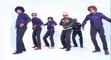 a group of men are dancing in a line with one wearing a shirt that says gts