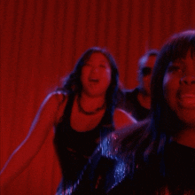 a group of people are dancing in a dark room