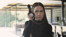 a woman in a black top is holding a pair of headphones