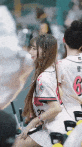 a girl wearing a number 6 jersey sits next to a girl wearing a number 29 jersey