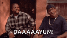 two men are sitting next to each other on a bench and one of them is saying `` daaaayum '' .
