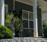 a man and a woman are standing outside a house with the number 50 on the porch