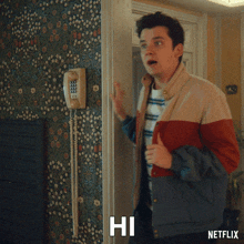 a man in a striped shirt and jacket says hi