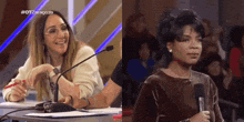 two women are sitting at a table with microphones and one of them is holding a microphone .