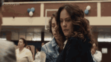 a woman stands next to a boy in a room with balloons on the wall and #jackryan written above her