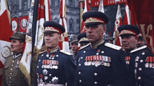 a group of men in military uniforms are standing in front of flags and a banner that says ' cccp ' on it