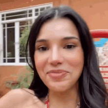 a close up of a woman making a funny face in front of a house .