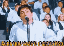 a man singing into a microphone in front of a crowd with the words acho querer poggerso on the bottom