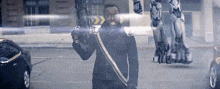 a man is holding a gun with a belt around his waist in front of a robot .