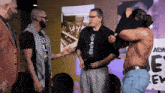 a group of men standing in front of a sign which says aew