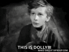 a black and white photo of a young boy with the words `` this is dolly '' written on it .