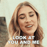 a woman says look at you and me while smiling with her eyes closed