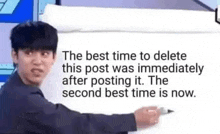 a man is standing in front of a white board with a marker and writing on it .