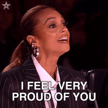 a woman in a suit is smiling and says i feel very proud of you