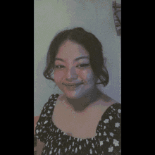 a woman wearing a black and white polka dot dress is smiling for the camera