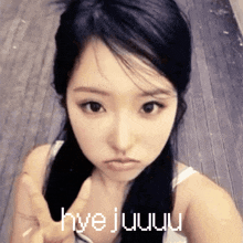 a woman giving a peace sign with the words hyejuuu written on her face