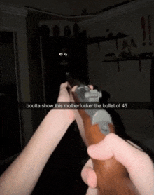 a person holding a rifle with a caption that says boutta show this motherfucker the bullet of 45