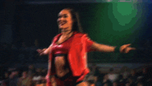 a woman in a red outfit is smiling and pointing at the camera