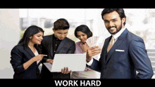 a man in a suit is holding a bunch of money and looking at a laptop ..