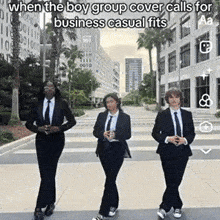 three men in suits and ties are walking down a street .